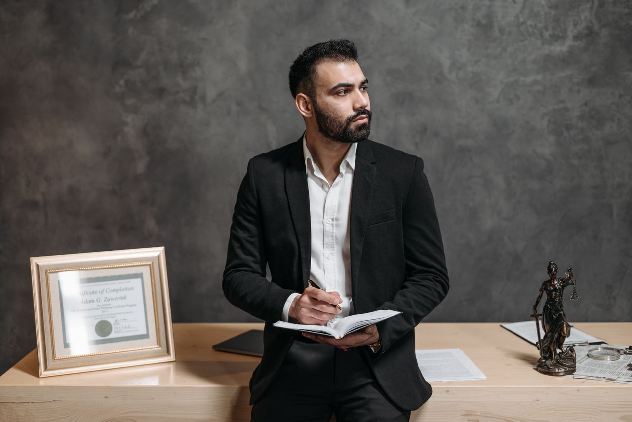 services-02 Confident male consultant takes notes, surrounded by legal paperwork in a modern office.